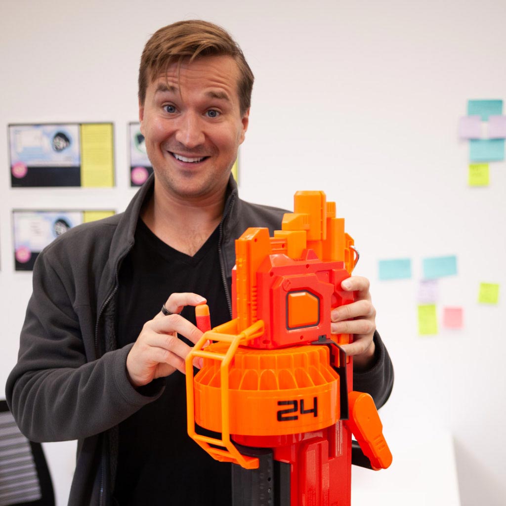 Photo of Nate loading a Nerf gun in an IDEO project space